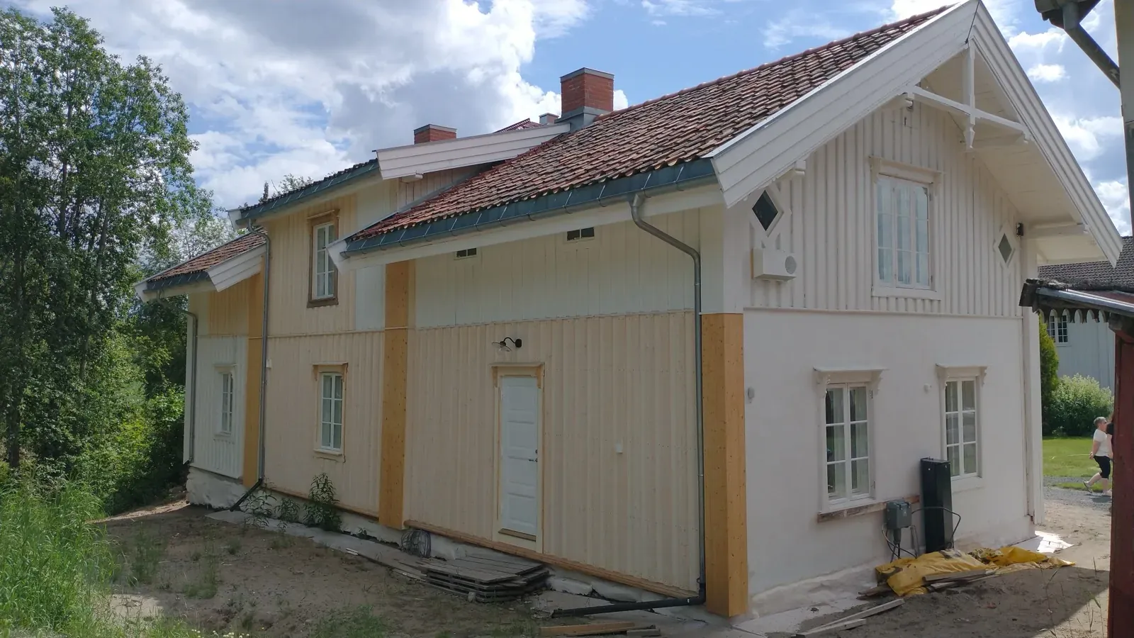 Ferdig renovert laftebygg med kremfarget kledning og rødt tegltak — vernet karakter utvendig, modernisert innvendig