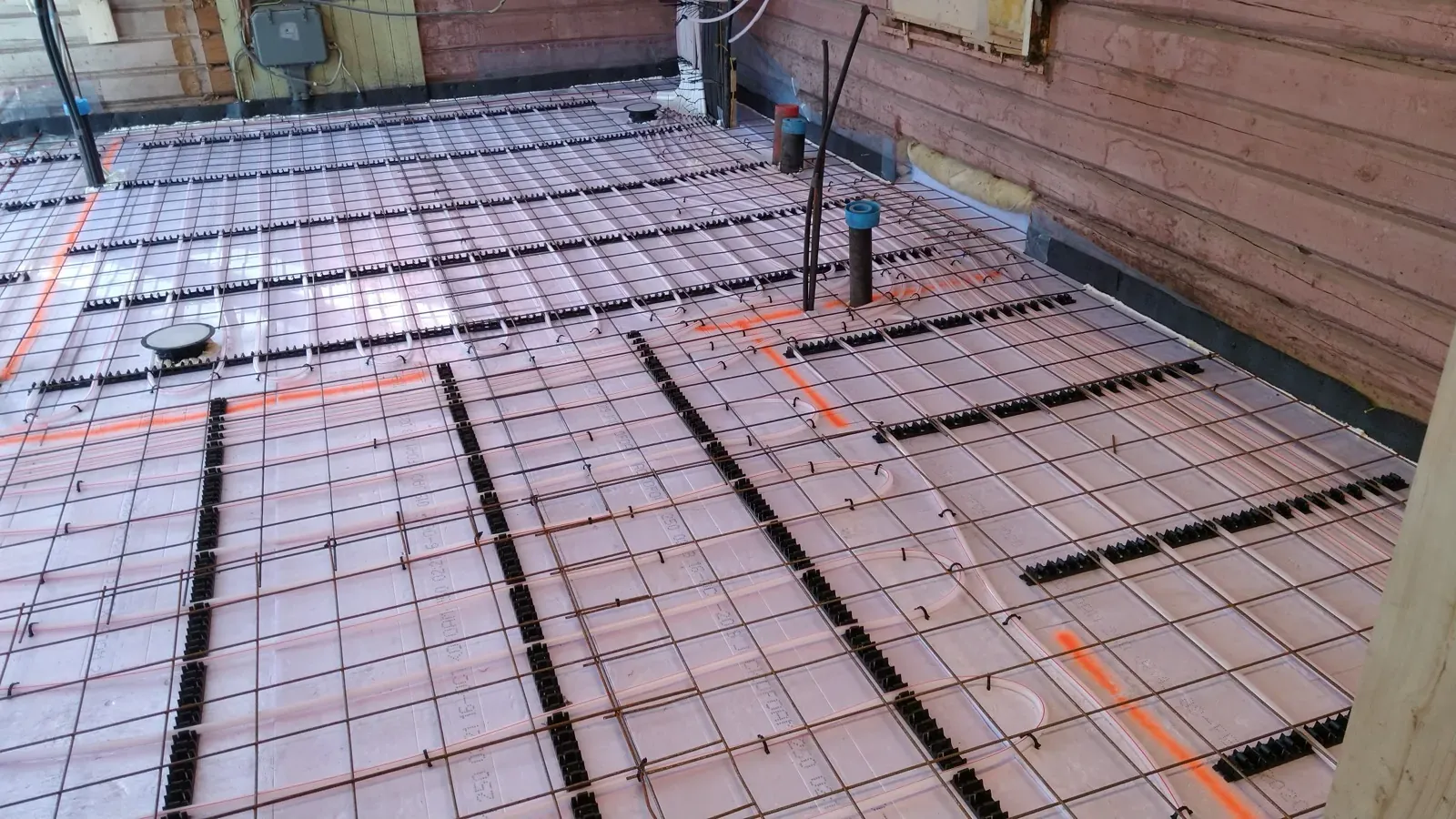 Varmerør lagt på løsleca med armering — klar for støping av betongplate med varmegulv