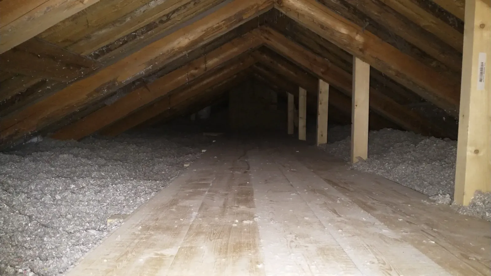 Miljøvennlig blåseisolasjon på loft — dekker over ventilasjonsrør og alle sprekker i gammel konstruksjon