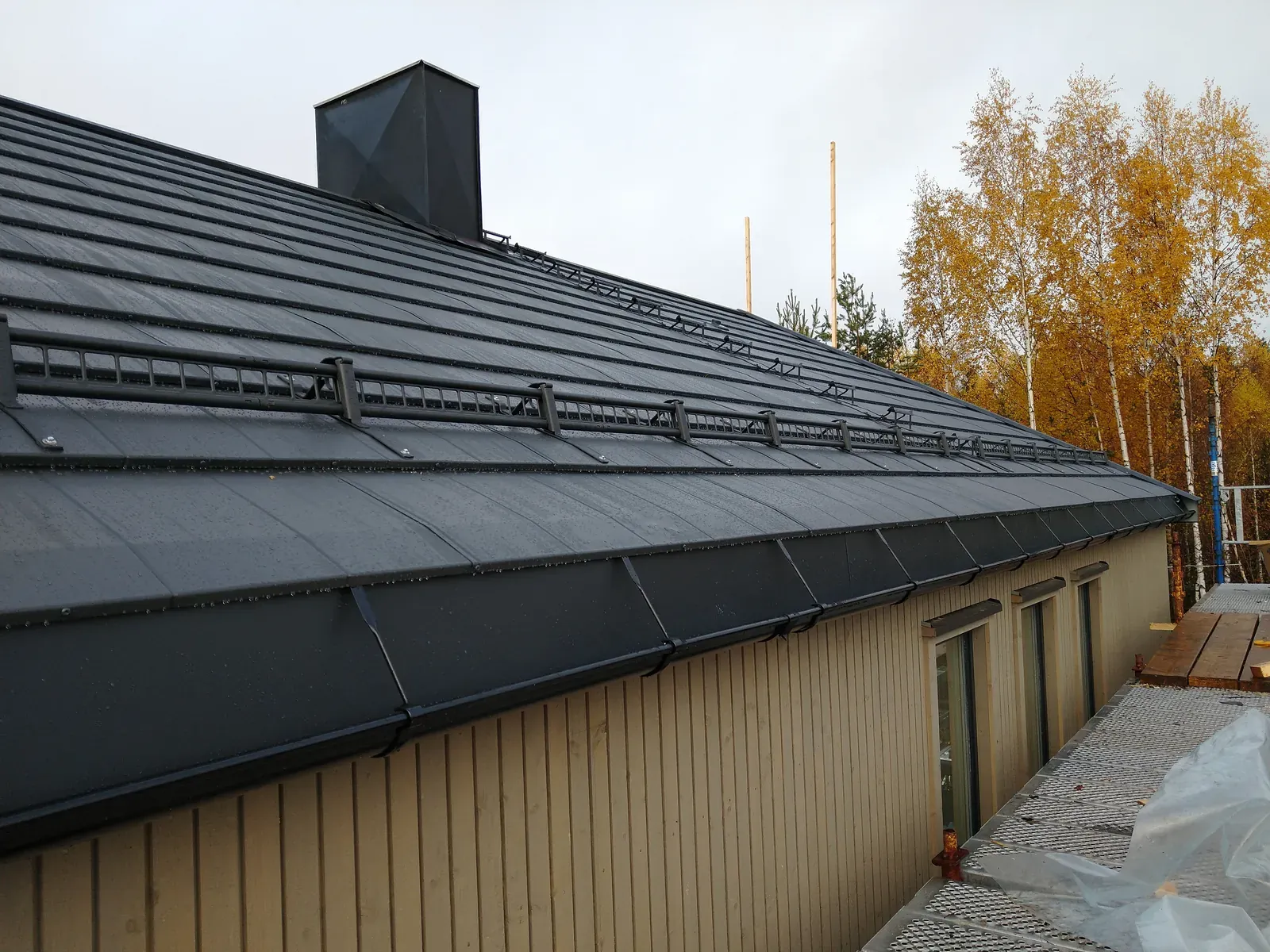 Ferdig mørkgrå metalltak med snefangere — nytt yttertak tilpasset husets stil.