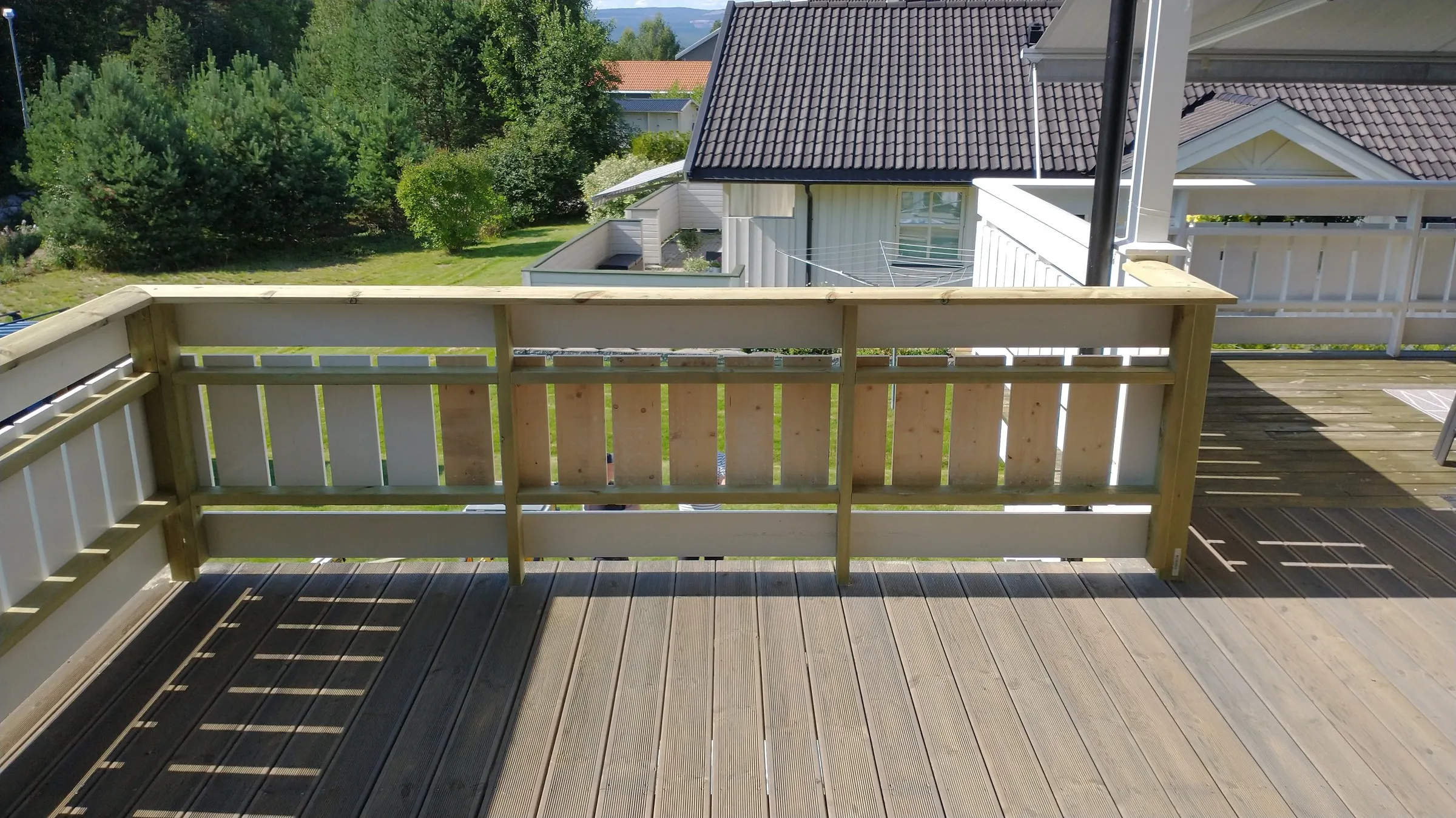 Detaljbilde av nytt trerekkverk på veranda — synlig snekkerhåndverk
