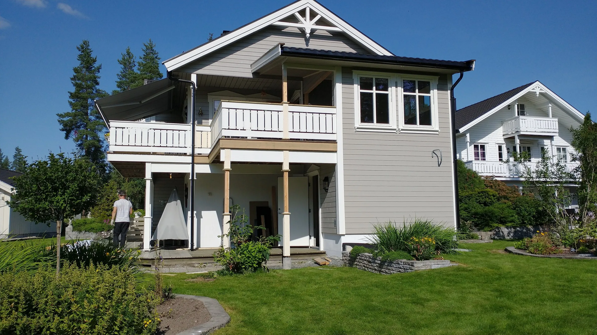 Ferdig veranda i to etasjer på klassisk villa, sommerdag med blå himmel